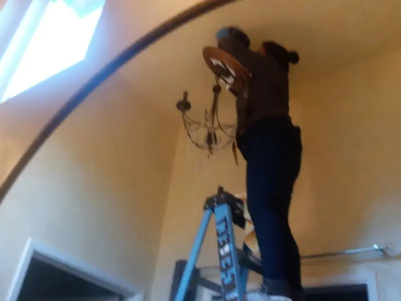 Electrician installing a chandelier in a Brookfield residence